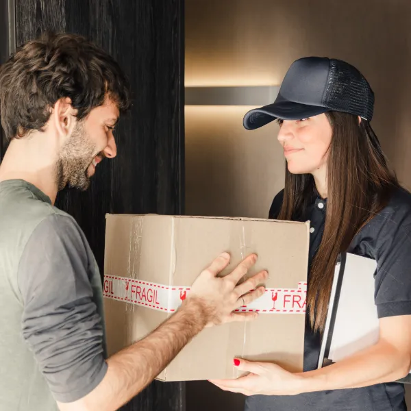 feliz-joven-recibe-paquete-de-mensajeria-femenina-en-el-hogar recogida y entrega a domicilio